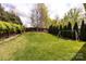 Lush backyard featuring a swing set, privacy landscaping, a mature tree, and a neatly cut lawn at 1550 Matthew Mcclure Cir, Davidson, NC 28036