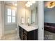 This well-lit bathroom features a marble countertop, dark wood cabinets, and a decorative mirror at 1550 Matthew Mcclure Cir, Davidson, NC 28036