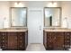 Bathroom featuring double sink vanities with dark wood cabinetry, stone counters, and brushed gold fixtures at 1550 Matthew Mcclure Cir, Davidson, NC 28036