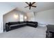 Spacious bonus room with vaulted ceilings, a ceiling fan, neutral carpeting, and a plush sectional couch at 1550 Matthew Mcclure Cir, Davidson, NC 28036