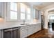 Bright kitchen features stainless steel appliances, marble counters and sleek white cabinetry and hardwood floors at 1550 Matthew Mcclure Cir, Davidson, NC 28036