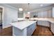 Spacious kitchen showcasing a large center island, modern cabinetry, marble countertops, stainless steel appliances, and hardwood floors at 1550 Matthew Mcclure Cir, Davidson, NC 28036