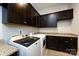 Functional laundry room with granite counters, ample dark wood cabinetry, modern washer and dryer set at 1550 Matthew Mcclure Cir, Davidson, NC 28036