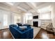 Stylish living room featuring a blue velvet sofa, fireplace, built-in shelves, and coffered ceiling at 1550 Matthew Mcclure Cir, Davidson, NC 28036