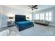 Bright main bedroom featuring a seating area and a large bed, a ceiling fan, and neutral carpeting at 1550 Matthew Mcclure Cir, Davidson, NC 28036