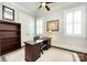 Well-lit office with a dark wood desk, neutral walls, and framed pictures, with a ceiling fan at 1550 Matthew Mcclure Cir, Davidson, NC 28036