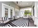 Inviting screened-in porch with a ceiling fan, comfortable seating, and a stylish black-and-white rug at 1550 Matthew Mcclure Cir, Davidson, NC 28036
