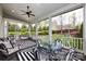 Screened porch with a modern ceiling fan, multiple seating areas, a glass table, and backyard views at 1550 Matthew Mcclure Cir, Davidson, NC 28036