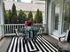 Charming porch with a striped rug, glass table and an open view of the backyard at 1550 Matthew Mcclure Cir, Davidson, NC 28036