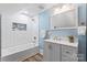 Well-lit bathroom featuring a tub with white subway tile, modern fixtures, and vanity with gray cabinets at 166 Franklin Nw Ave, Concord, NC 28025