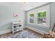 Bright bedroom with wood floors, changing table, and double windows offering lots of natural light at 166 Franklin Nw Ave, Concord, NC 28025