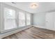 Bright bedroom featuring hardwood floors, neutral walls, and three windows at 166 Franklin Nw Ave, Concord, NC 28025