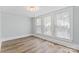 Light-filled bedroom with hardwood floors, neutral paint, and three large windows at 166 Franklin Nw Ave, Concord, NC 28025
