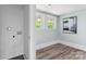 Bright room with hardwood floors, two windows, and an abstract artwork on the blue walls at 166 Franklin Nw Ave, Concord, NC 28025