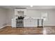 Bright kitchen featuring white cabinets, stainless steel appliances, and wood-look floors at 170 Dusty Loop Dr, Mount Gilead, NC 27306