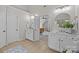 Bathroom with dual vanities, mirrors, and tile flooring leading to the main bedroom at 1809 Robbins Meadows Dr, Waxhaw, NC 28173