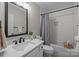 Bright bathroom featuring a shower with white subway tile, a quartz countertop, and a black framed mirror at 1809 Robbins Meadows Dr, Waxhaw, NC 28173