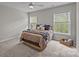 Comfortable bedroom with carpet, neutral walls, two windows, ceiling fan and decoratively styled bed at 1809 Robbins Meadows Dr, Waxhaw, NC 28173