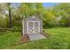 Outdoor backyard shed with gray siding, a white trim and double doors, on a well-maintained lawn at 1809 Robbins Meadows Dr, Waxhaw, NC 28173
