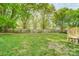 The backyard features a lush green lawn, mature trees, and a wooden fence for privacy and enjoyment at 1901 Parkdale Ave, Gastonia, NC 28052