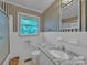 Bright bathroom with granite countertop and white tiled walls with striped wallpaper at 1910 York Hwy, York, SC 29745