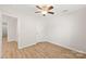 Bedroom features wood laminate flooring, ceiling fan, and an entry door at 219 Edinburgh Ct, Mount Holly, NC 28120