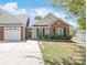 Charming single-story home featuring a brick facade, well-manicured lawn, and a two-car garage at 219 Edinburgh Ct, Mount Holly, NC 28120