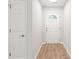 Hallway with wood flooring leading to a front door with glass detailing at 219 Edinburgh Ct, Mount Holly, NC 28120