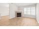 Bright living room featuring a fireplace, wood flooring, and a large window at 219 Edinburgh Ct, Mount Holly, NC 28120