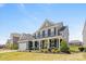 Charming two-story home with a welcoming front porch, well-manicured lawn, and lush landscaping for curb appeal at 235 Boxelder Rd, Clover, SC 29710