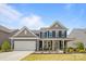 Charming two-story home with a well-manicured lawn, inviting front porch, and attached two-car garage at 235 Boxelder Rd, Clover, SC 29710