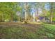 Spacious backyard with a mix of cleared areas and mature trees, surrounded by a chain-link fence at 2371 Lazy Oak Dr, Lancaster, SC 29720