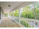 Spacious covered porch featuring a wooden floor and a view of the wooded front yard at 2371 Lazy Oak Dr, Lancaster, SC 29720
