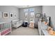 Bright Bedroom features white cribs, cozy armchairs and decor, complemented by natural light from shuttered windows at 2401 Euclid Ave, Charlotte, NC 28203