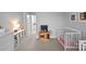 Neutral bedroom design features a play kitchen, crib and wall shelving in a minimalist style at 2401 Euclid Ave, Charlotte, NC 28203