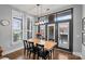 Bright dining room with a light wood table, black chairs and black framed glass doors to the outside patio at 2401 Euclid Ave, Charlotte, NC 28203