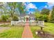 Quaint home with a white picket fence, brick pathway and walkway, set amidst lush green lawns and mature trees at 292 Mocksville Hwy, Statesville, NC 28625