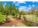 Lush greenery, garden statues, and brick pathways adorn this home's charming, fenced-in front yard at 292 Mocksville Hwy, Statesville, NC 28625