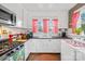 Well-lit kitchen with white cabinets, stainless steel appliances, and red checkered curtains at 292 Mocksville Hwy, Statesville, NC 28625