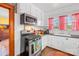 Well-lit kitchen with white cabinets, stainless steel appliances, and checkered curtains at 292 Mocksville Hwy, Statesville, NC 28625