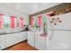 Bright kitchen and laundry area with white cabinets and red checkered curtains at 292 Mocksville Hwy, Statesville, NC 28625