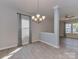 Dining area with modern chandelier, gray walls, and luxury vinyl flooring with windows overlooking backyard at 317 Contentment Dr, Locust, NC 28097