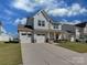 Charming two-story home with a well-manicured lawn and three car garage at 317 Contentment Dr, Locust, NC 28097