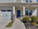 Home exterior showing front entrance with a blue door, stone accents, and manicured landscaping at 317 Contentment Dr, Locust, NC 28097