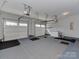 Spacious two-car garage featuring epoxy flooring, storage, and updated lighting at 317 Contentment Dr, Locust, NC 28097