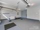 Spacious two-car garage featuring epoxy flooring, storage, and updated lighting at 317 Contentment Dr, Locust, NC 28097