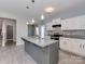 Modern kitchen showcasing a center island, sleek appliances, and a view into the staircase at 317 Contentment Dr, Locust, NC 28097