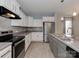 Stylish kitchen features white cabinets, gray countertops, stainless steel appliances, and wood-look flooring at 317 Contentment Dr, Locust, NC 28097