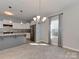 Eat-in kitchen area featuring white cabinets, stainless steel appliances, pendant lighting, and hardwood floors at 317 Contentment Dr, Locust, NC 28097