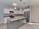 Bright kitchen with gray island, pendant lighting, stainless steel appliances, and ample cabinet space at 317 Contentment Dr, Locust, NC 28097
